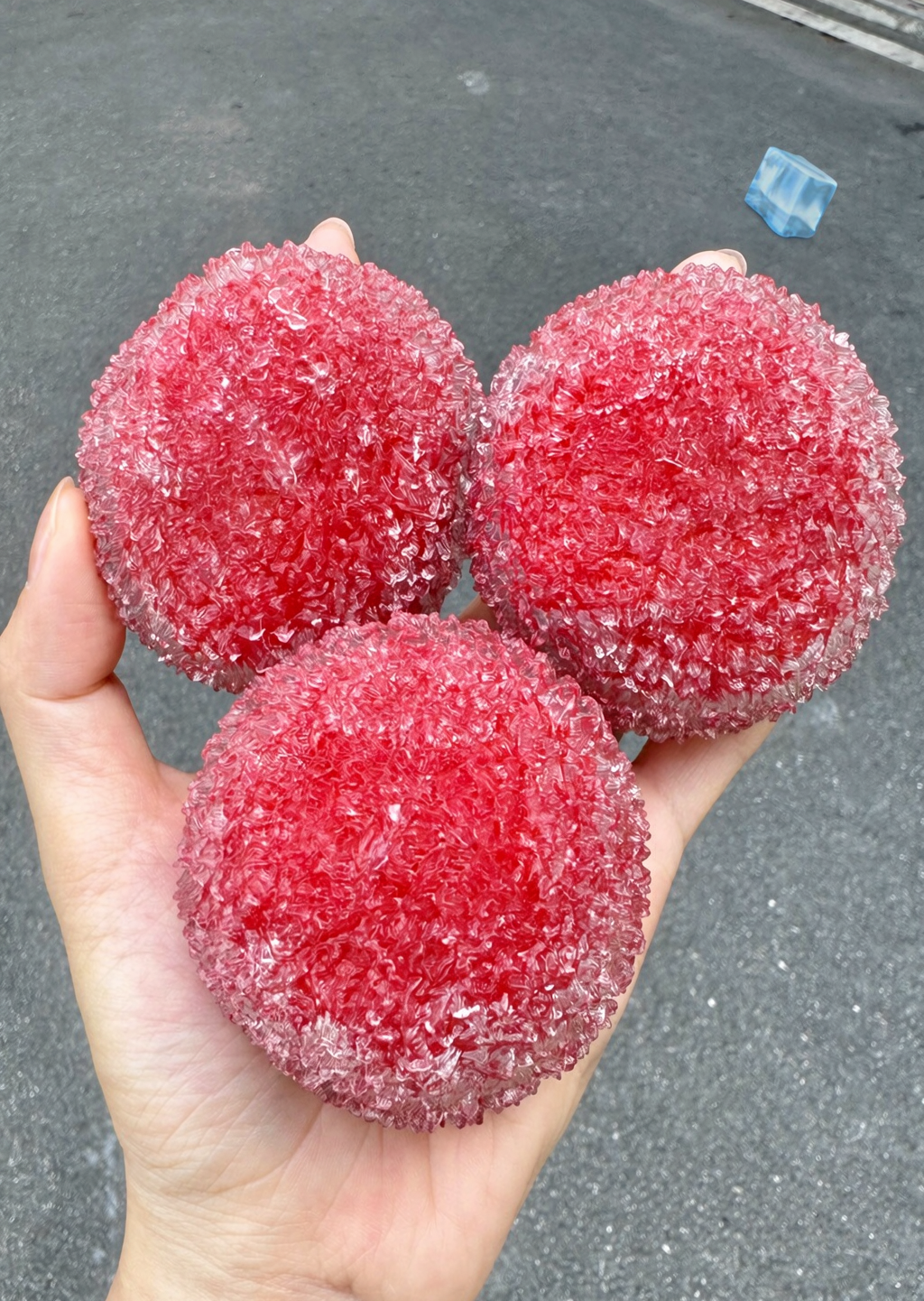 Three handmade frosted bayberry ice squishy balls held in one hand